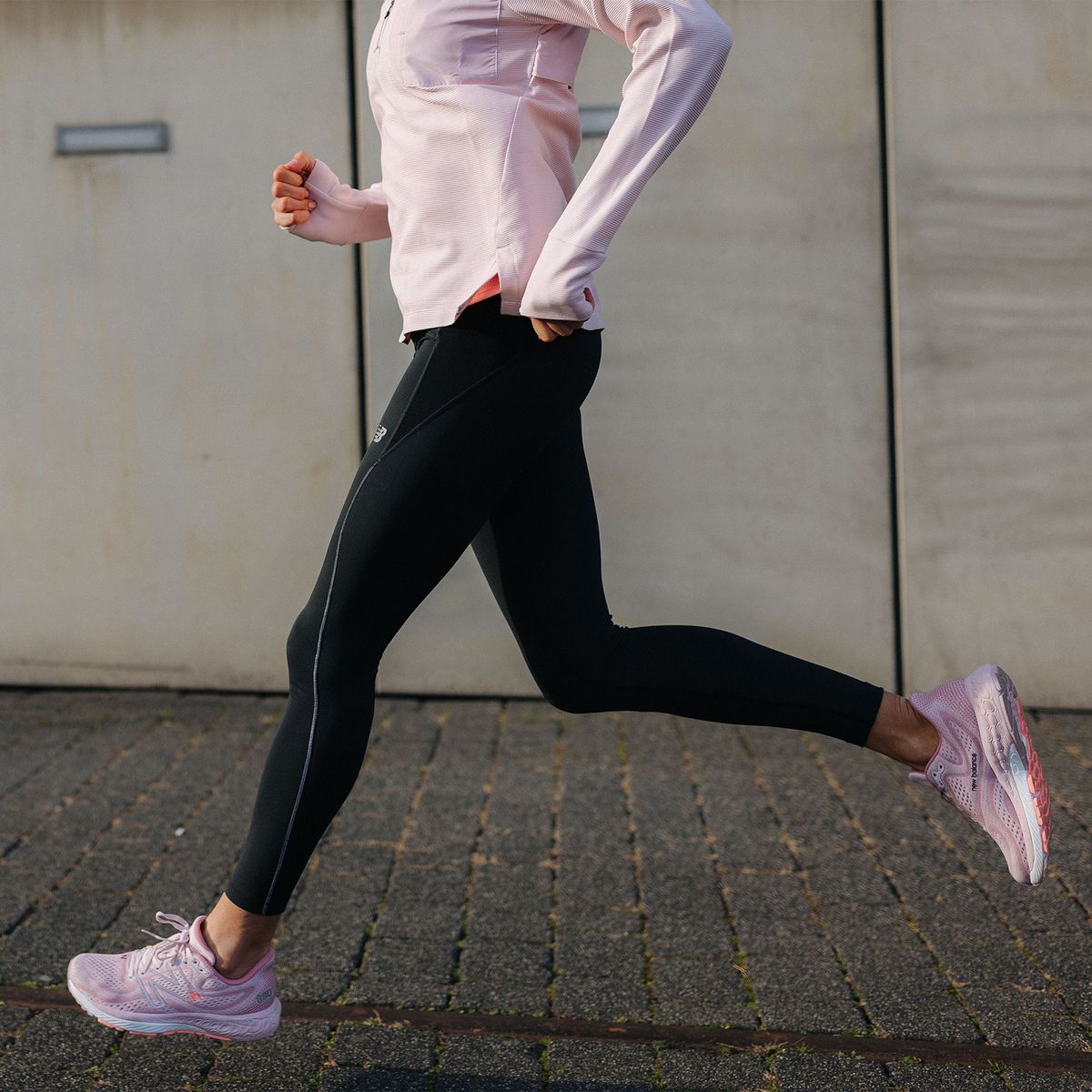Egy nő rózsaszín New Balance cipőben fut
