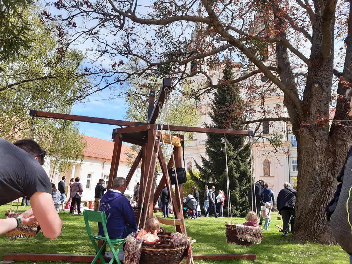 A gyerekek a Zirci Ciszterci Apátság díszudvarában megint kipróbálhatják a kosaras körhintát és élvezhetik a népi fajátékokat 