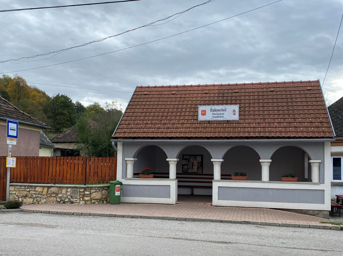 A Bakonybél központjában lévő buszmegálló rímel a tájház boltíves, oszlopos tornácára. Büszkék is rá a helybeliek, a turisták pedig szelfizőhelynek, fotópontnak használják