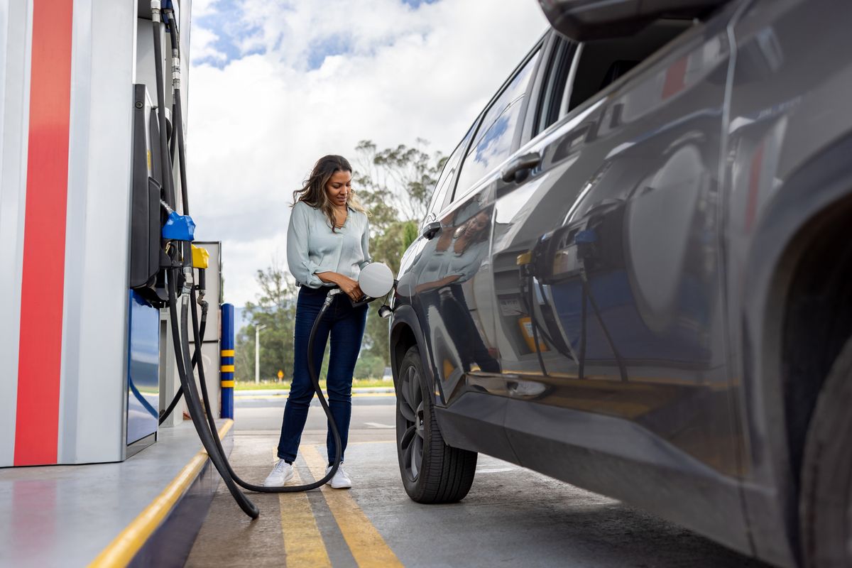 Woman putting gas in her car at a petrol station
üzemanyag