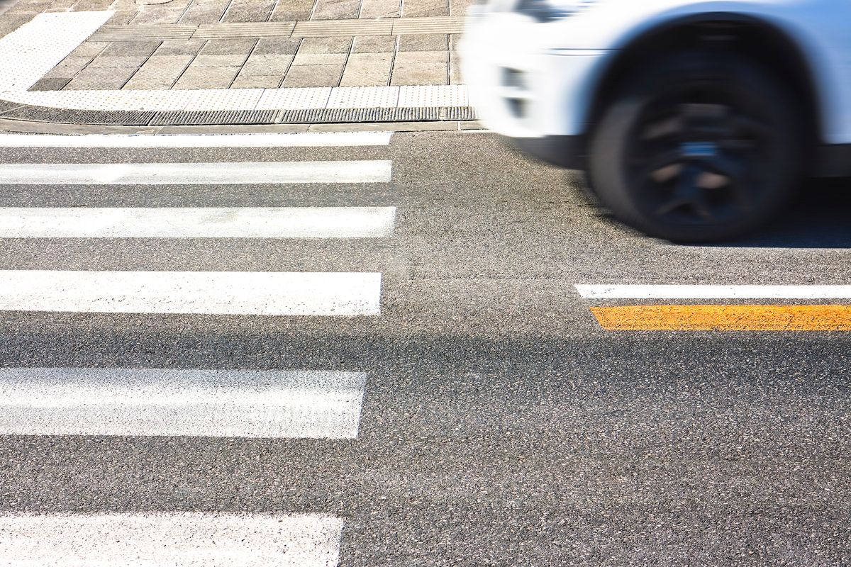 Black and white pedestrian crossing with car on background - image with copy space
gyalogosgázolás