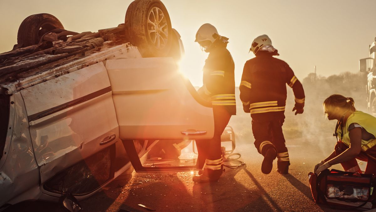 Car Crash Traffic Accident: Paramedics and Firefighters Plan Rescuing Passengers Trapped in Rollover Vehicle. Medics Prepare Stretchers and First Aid Equipment. Firemen Use Hydraulic Cutters Spreader
baleset