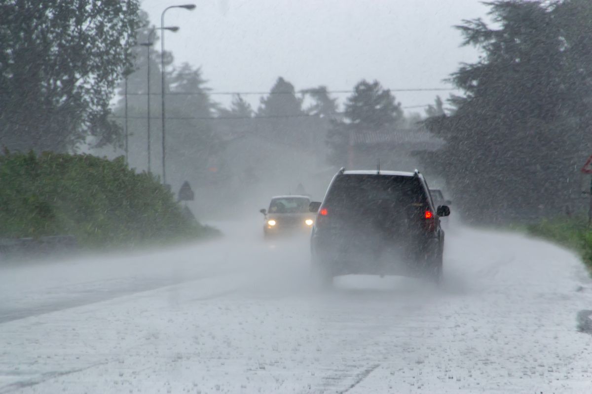 The strong storm with heavy rain on the road with poor visibility of cars. Concept of the danger of driving in bad weather
időjárás