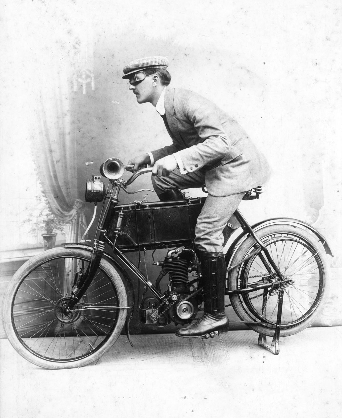 Göricke típusú motorkerékpáron ülő férfiról 1906-ban műteremben készült beállított fotó.