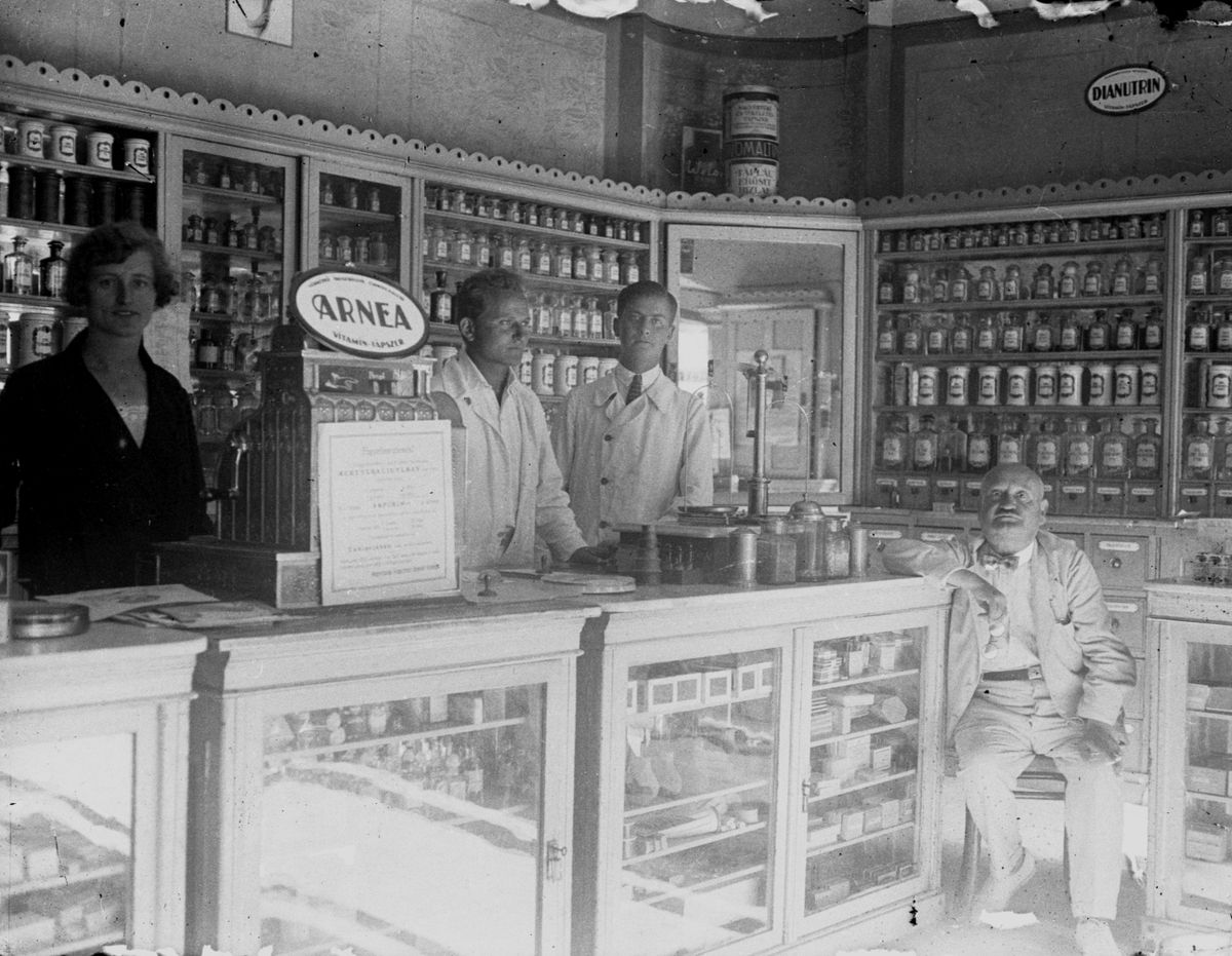 Időutazás régi képek alapján – A Fekete Sas gyógyszertár, Veszprém első patikája 1924-ben és az ott dolgozók, egy asszisztens, Kocsuba Elemér, Karabélyos Endre és Kocsuba Emil.